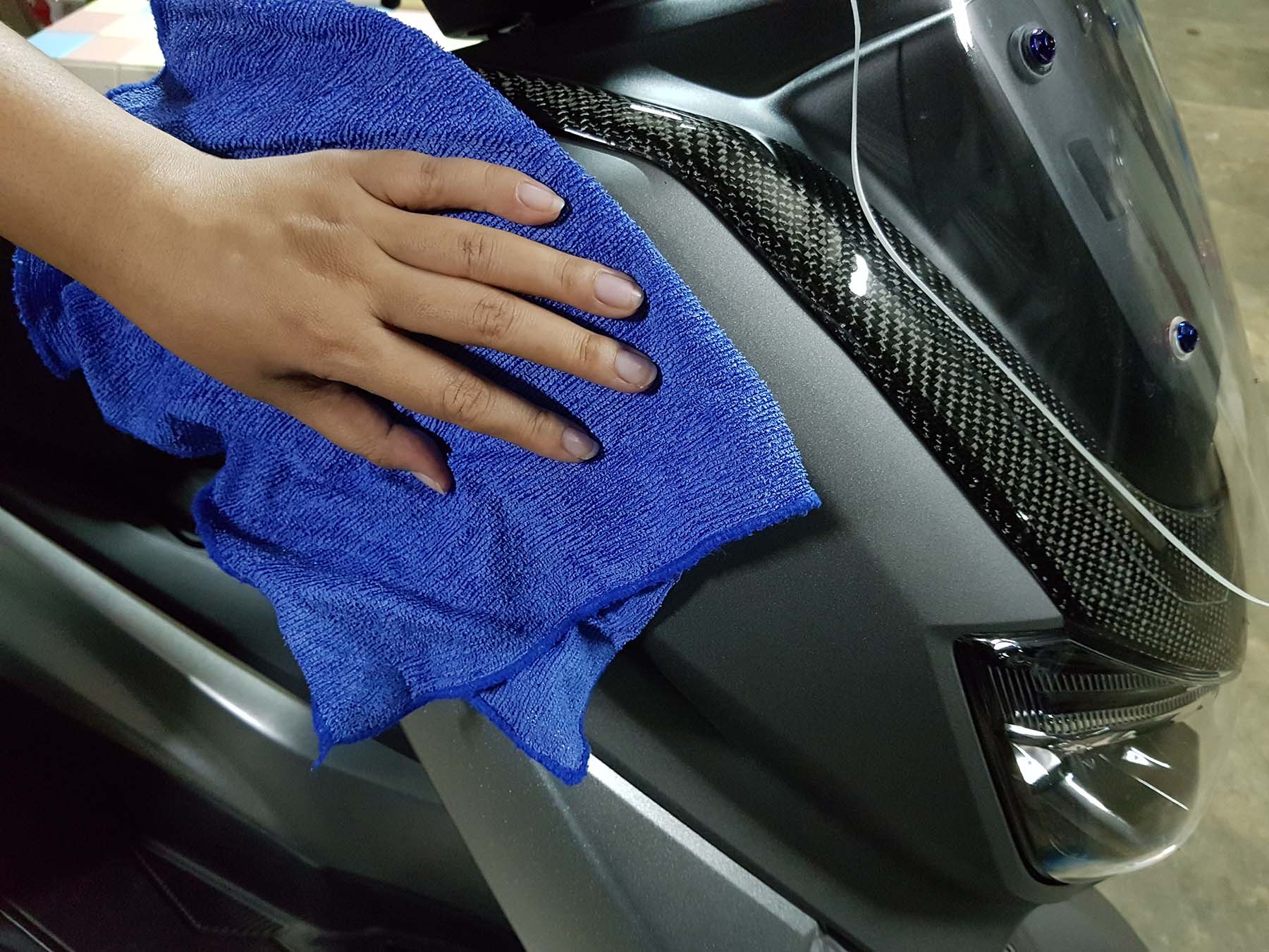 limpiar parabrisas de motocicleta con toalla de microfibra y aspecto brillante de la motocicleta después de la limpieza